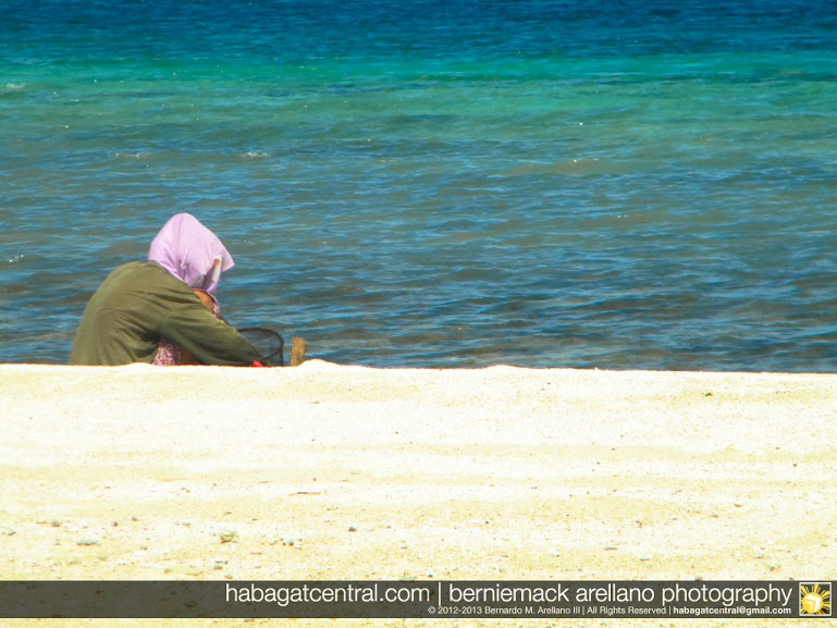 A local woman collecting sigay shells